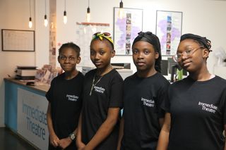 Four young people standing in a line, wearing black Immediate Theatre T-shirts